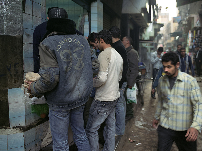  Fotografie Trh v Káhiře, Egypt - Lidé kupující arabský chléb na tržišti v Káhiře.